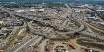 Aerial view of a major highway infrastructure project under construction in a US city.